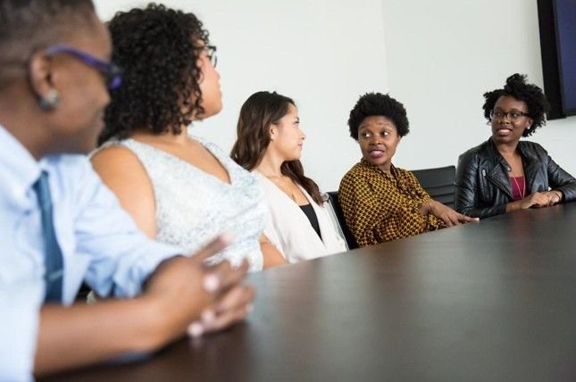 Team members in an office conference room collaborating to improve accuracy and consistency in business proposals